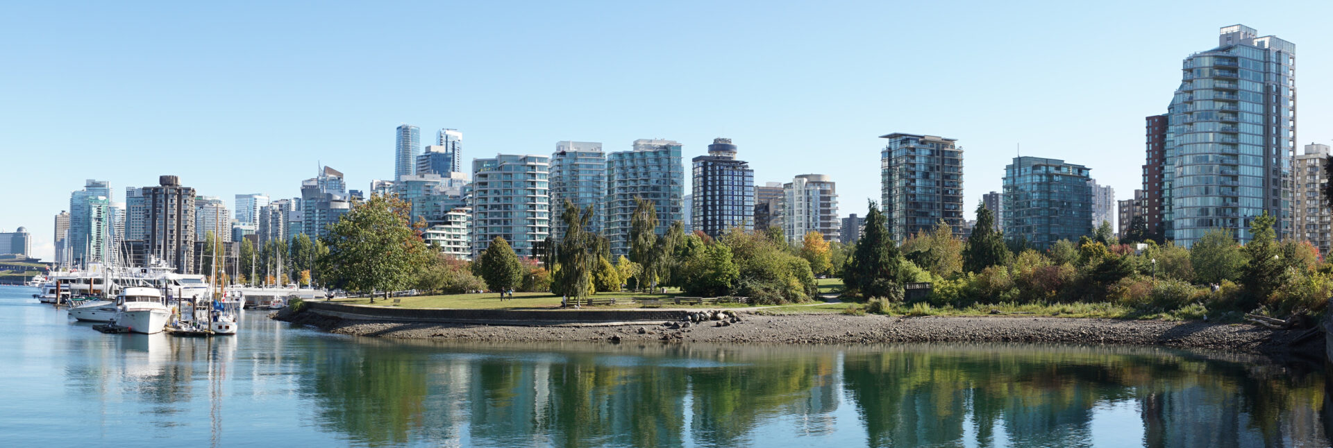 Skyscraper and city landscape on a sunny day with boats in Vancouver, Canada.