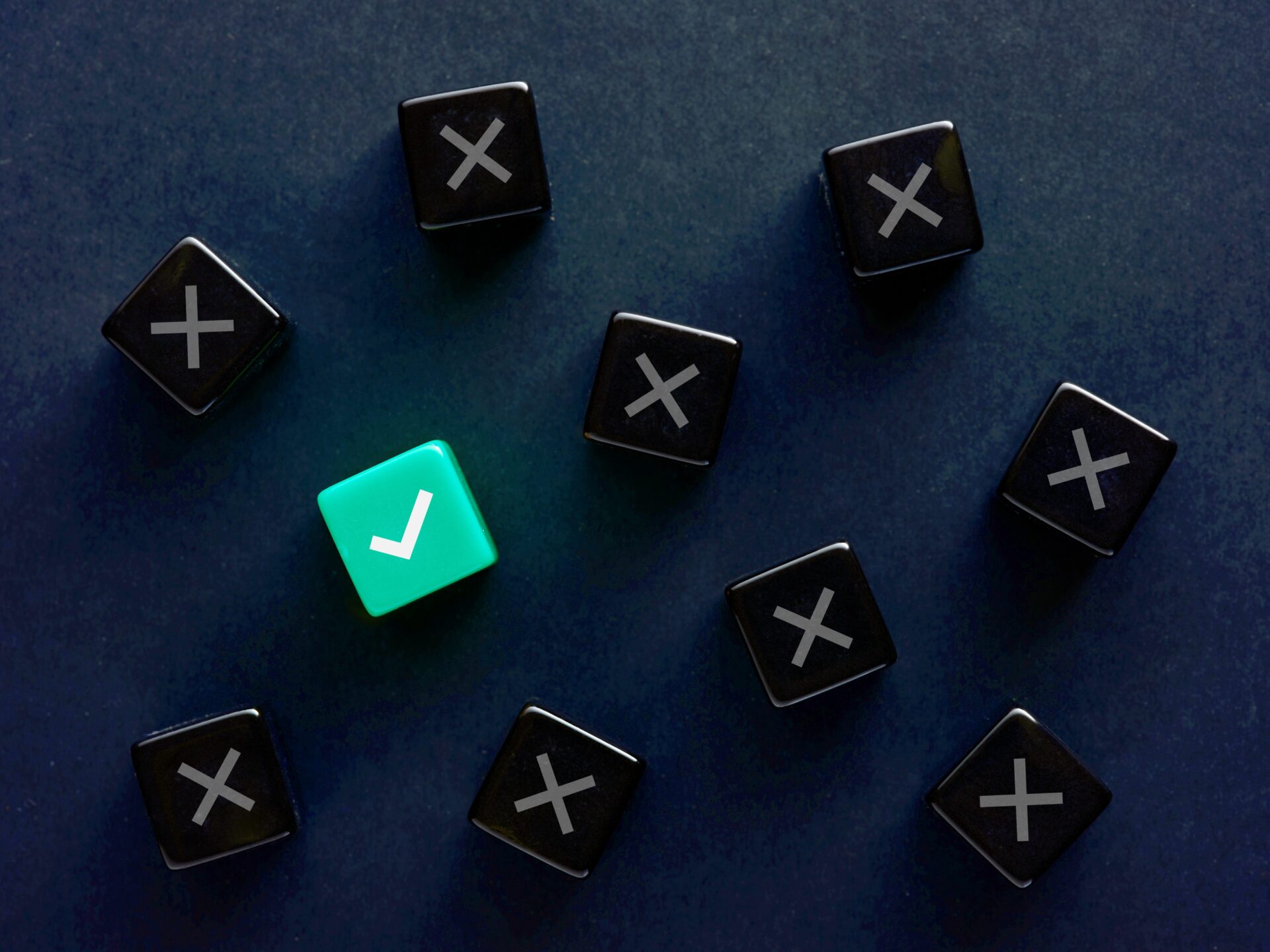 Bright teal checkmark die among a field of black x dice.